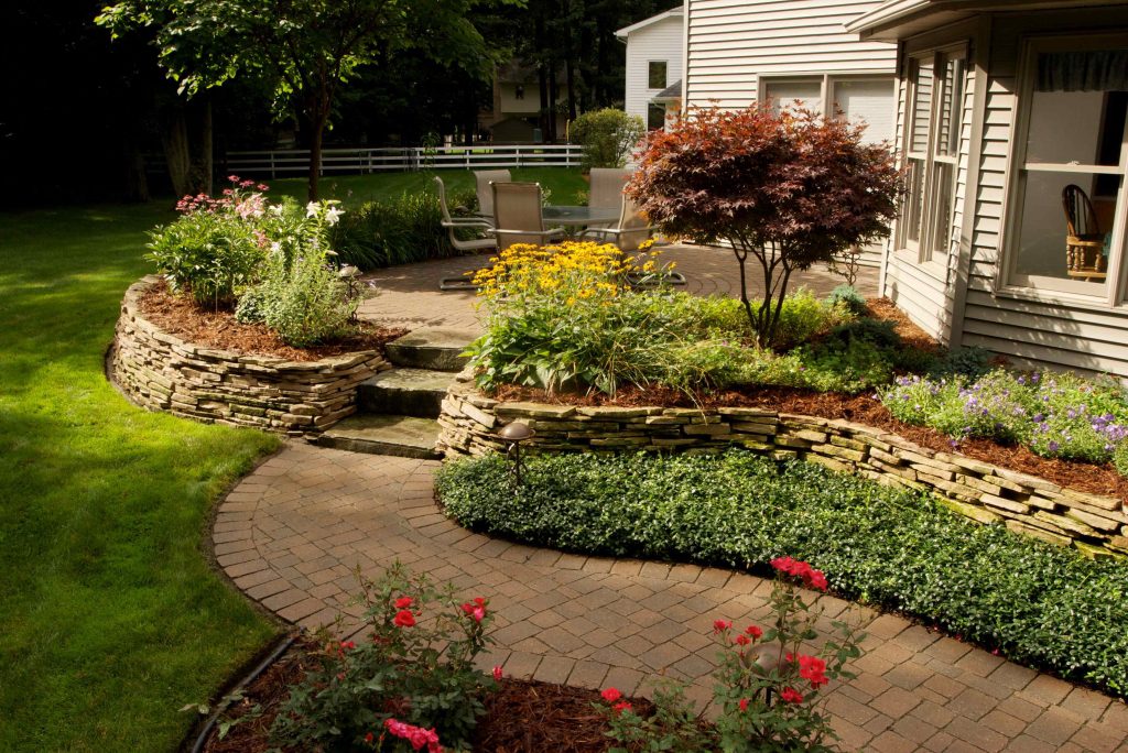 Landscaping a backyard with pavers, stone & raised patios